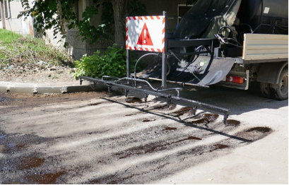 An industrial vehicle applying seal coating on a road
