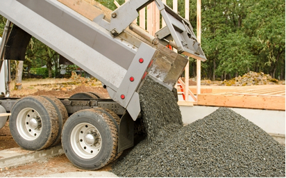 A gravel hauling truck dumping gravel