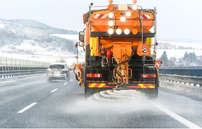 A spreader spreading salt on an icy road